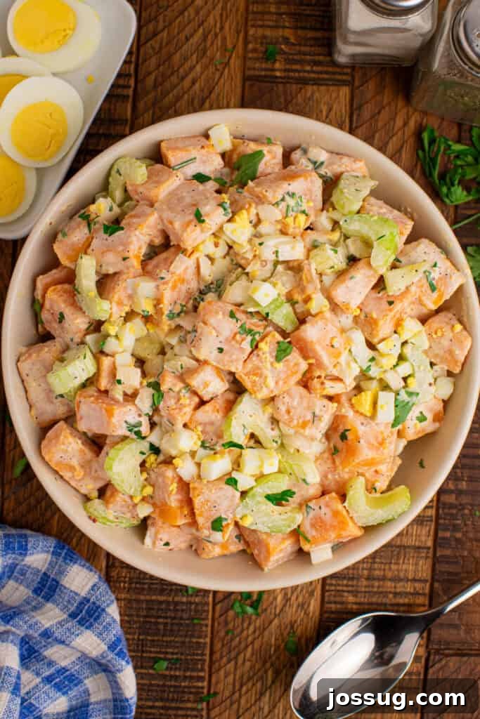 Southern-Style Sweet Potato Salad Recipe 2 Overhead view of creamy Sweet Potato Salad topped with chopped hard-boiled eggs and fresh parsley
