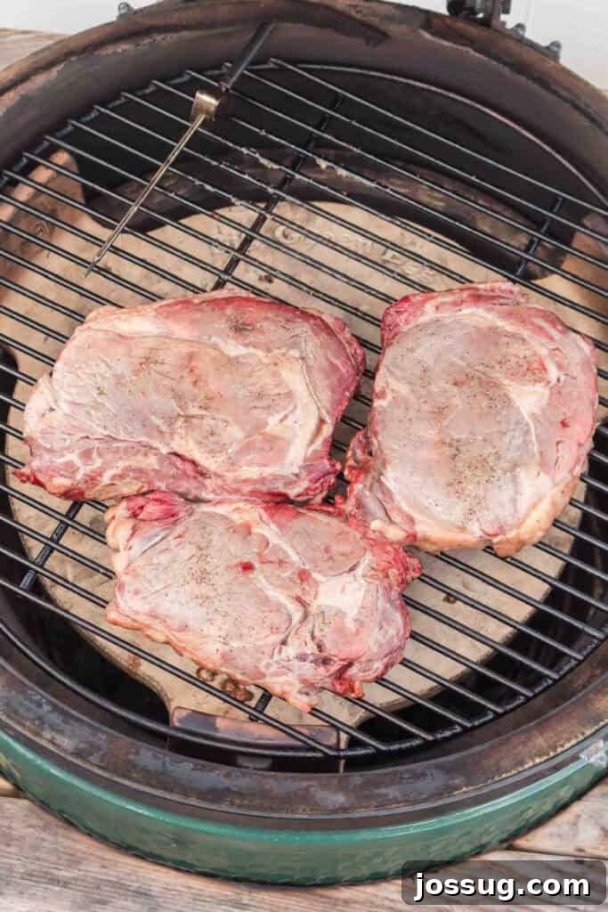 Ribeye steaks cooking slowly on the grill before the high-heat reverse sear.