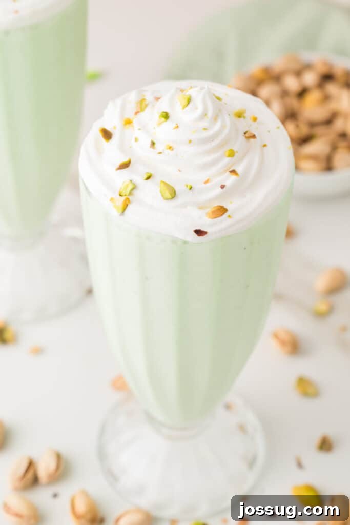 Close-up of whipped cream and chopped pistachios on top of a creamy pistachio shake
