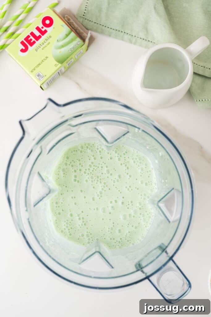 Pale green pistachio milkshake blended until smooth in a blender