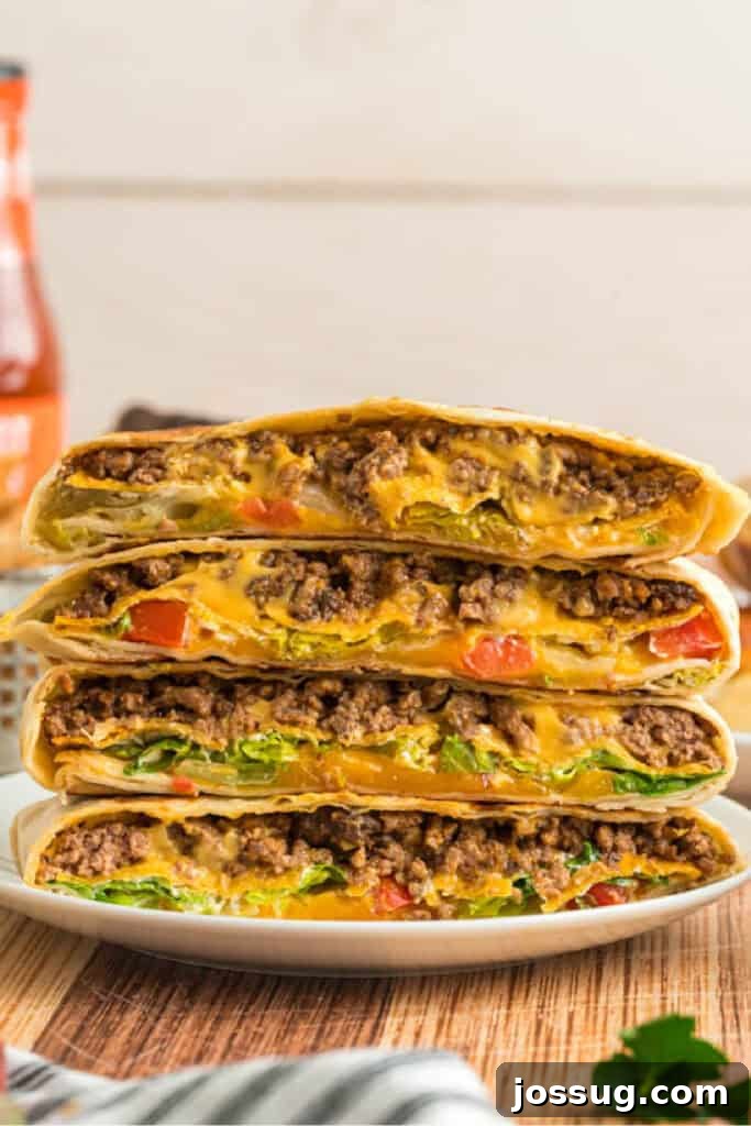 Stack of cut Crunchwrap Supremes showing layers of beef, cheese, lettuce, and tomatoes