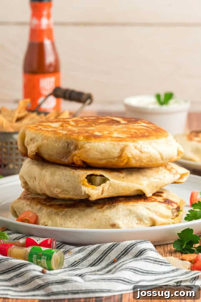 Three crispy homemade Crunchwrap Supremes stacked on a serving plate