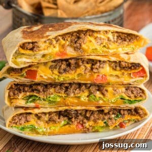 Crunchwrap Supreme stacked with seasoned ground beef, melted cheese, lettuce, and tomatoes visible inside