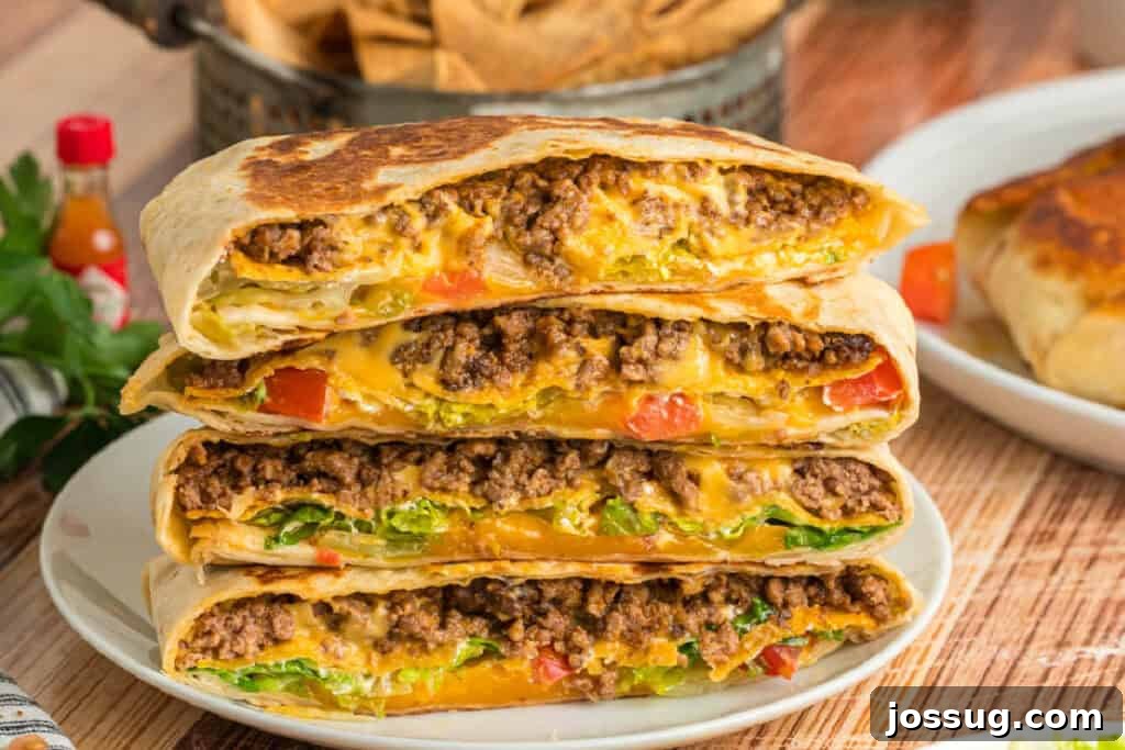 Four Crunchwrap Supreme halves stacked to show the cheesy ground beef and fresh vegetable filling