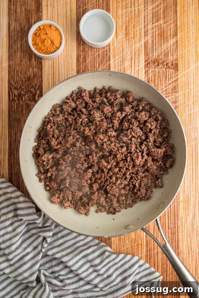 Ground beef browning in a skillet for Crunchwrap Supreme