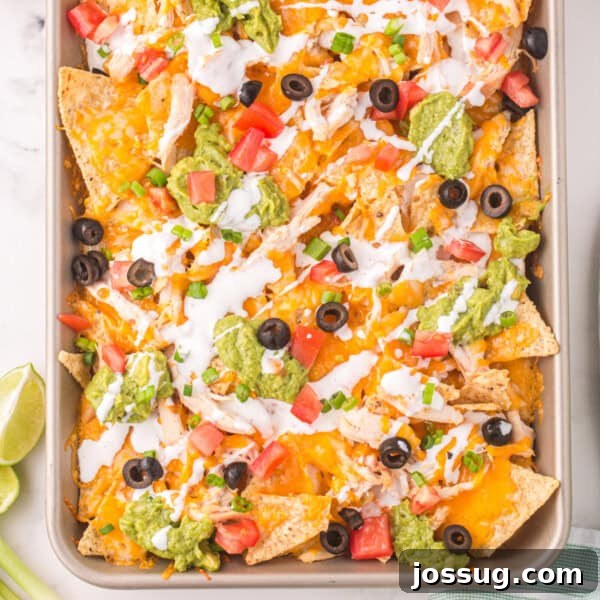 closeup of chicken nachos on sheet pan