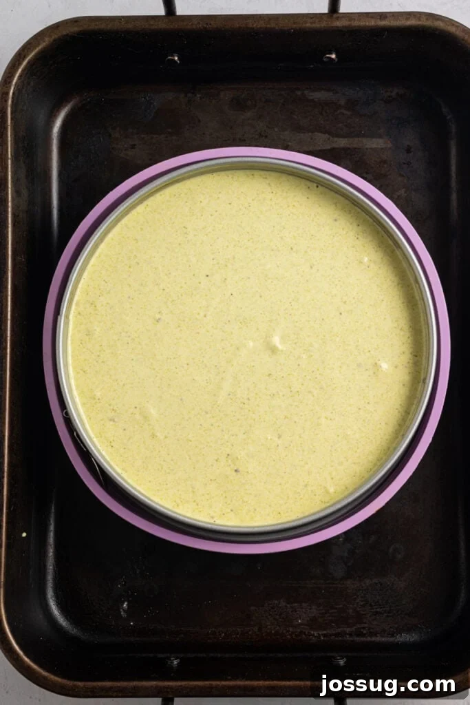 Pistachio Cheesecake with White Chocolate-Pistachio Ganache 11 Pistachio Cheesecake batter in a springform pan set inside a roasting pan for a water bath