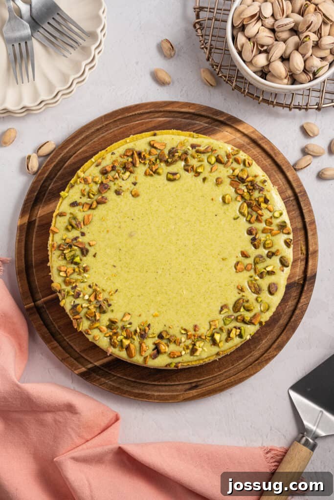Pistachio Cheesecake with White Chocolate-Pistachio Ganache 12 Whole Pistachio Cheesecake topped with chopped pistachios on a wooden serving board