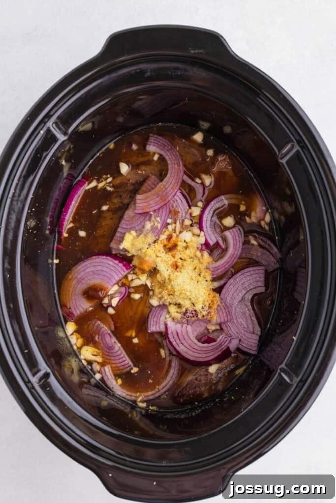 Slow Cooker Asian Pot Roast with Ginger Soy Glaze 5 Seared chuck roast in a slow cooker with sliced onion, fresh ginger, garlic, beef stock, and soy sauce