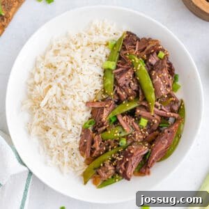 Slow Cooker Asian Pot Roast with Ginger Soy Glaze 9 Slow Cooker Asian Pot Roast served over white rice with tender beef, snap peas, green onions, and sesame seeds