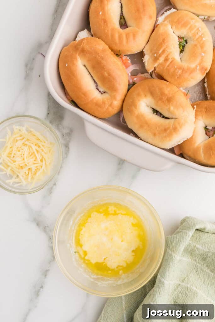 Baked Bagel and Smoked Salmon Sliders 12 Melted butter in a bowl beside assembled Baked Bagels & Lox Sliders