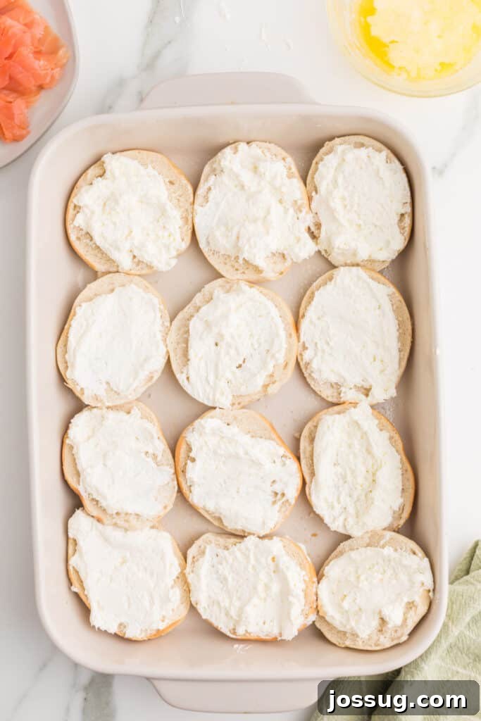 Baked Bagel and Smoked Salmon Sliders 6 Mini bagel bottoms spread generously with whipped cream cheese in a baking dish