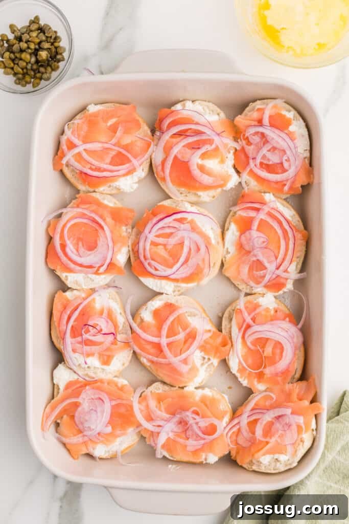 Baked Bagel and Smoked Salmon Sliders 8 Thinly sliced red onion added over smoked salmon and cream cheese on mini bagels