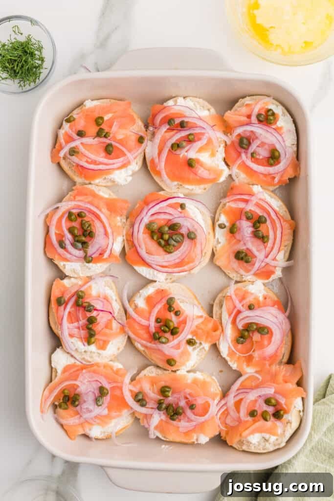 Baked Bagel and Smoked Salmon Sliders 9 Capers scattered over smoked salmon and red onion while assembling bagel and lox sliders