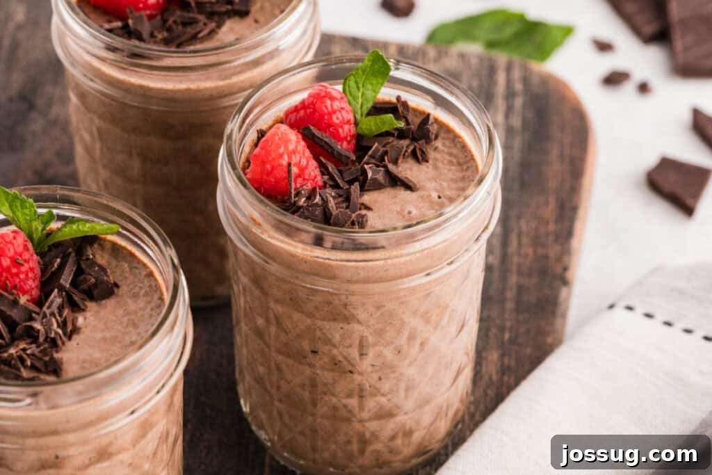 Creamy Chocolate Chia Pudding Recipe 4 Three jars of Chocolate Chia Pudding topped with raspberries, dark chocolate, and mint