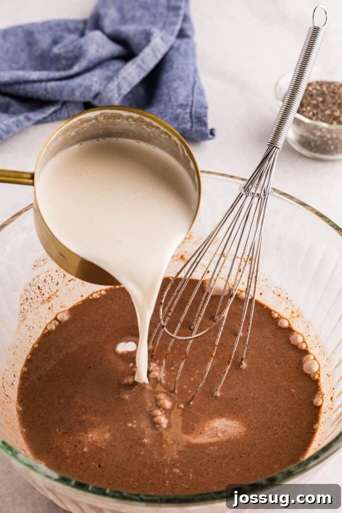 Creamy Chocolate Chia Pudding Recipe 7 Cold almond milk being poured into the chocolate mixture before adding chia seeds