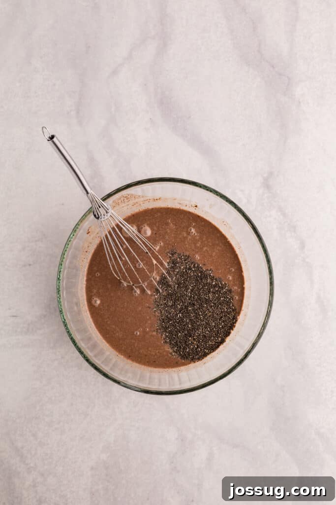 Creamy Chocolate Chia Pudding Recipe 8 Chia seeds added to the chocolate mixture in a glass bowl before whisking